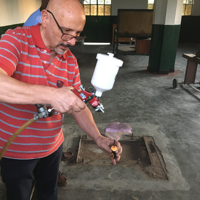 Roberto Postelmans spraying a piece of foam with an Ottobock Superskin coating for cosmetic purposes.  HVP-Gatagara | Gatagara, Rwanda.  