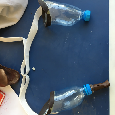 A set of custom prostheses for a bilateral upper limb amputee, with thermoformed water bottle sockets and 3D printed end effectors.  Lake Victoria Disability Centre | Musoma, Tanzania.  