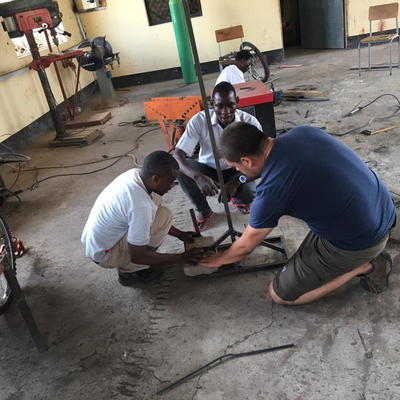 Kyle Reeser helping out in the metal shop at LVDC.  The Lake Victoria Disability Centre Campus consisted of many yellow buildings with corrugated metal roofs, all built and maintained by LVDC staff.  Lake Victoria Disability Centre | Musoma, Tanzania.