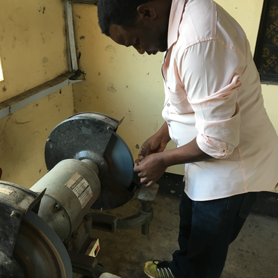 Bob, a technician in the P&O department at LVDC, shapes a thermoformed insert in a grinder.  Lake Victoria Disability Centre | Musoma, Tanzania.  